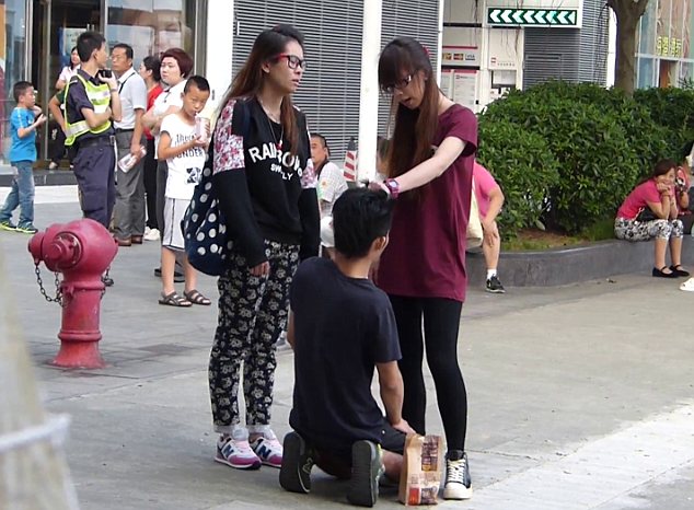Harsh: A woman from Hong Kong was filmed slapping her boyfriend as he kneeled in the street in front of her