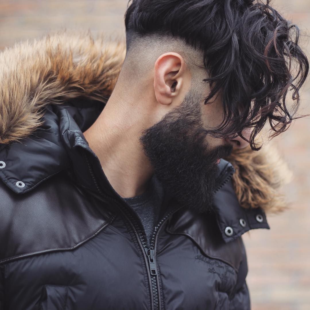 Long curly fringe undercut hairstyle for men